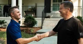 A satisfied homeowner shakes hands with a Window Hero professional.