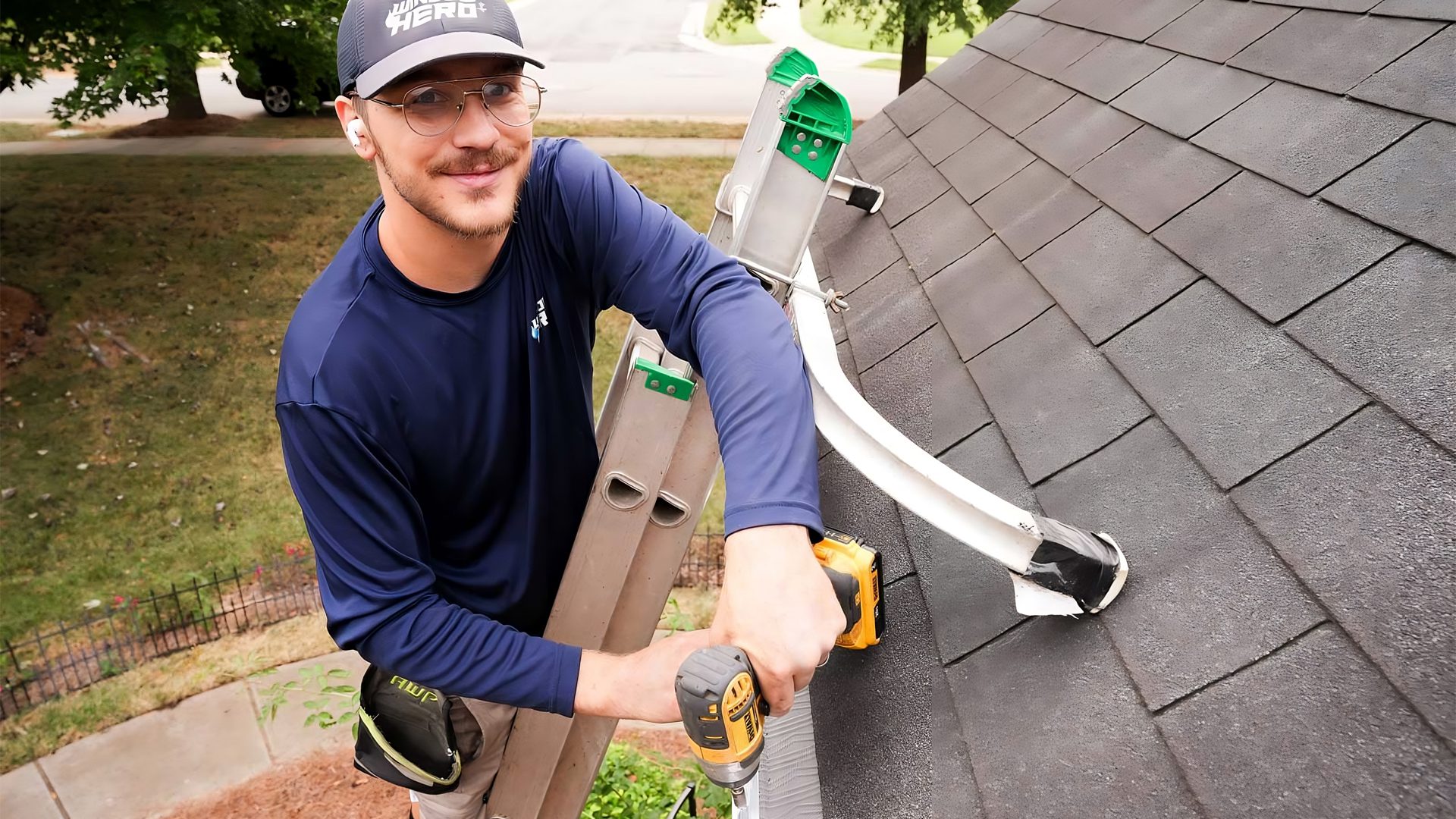 A Window Hero professional using a power drill to install a gutter guard.